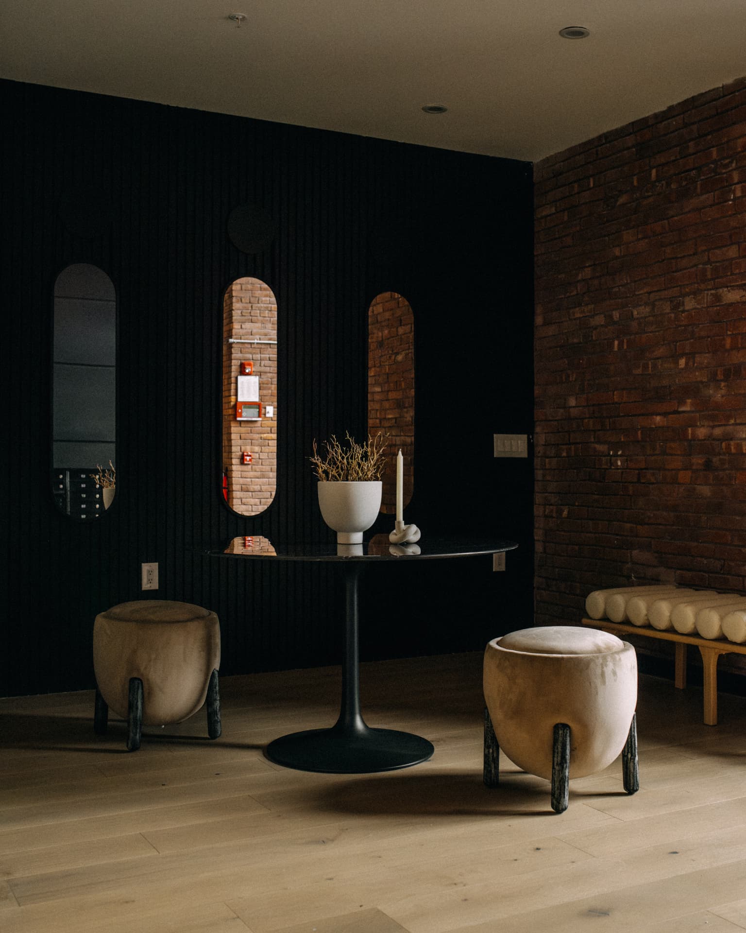 328 Pacific Ave — lobby lounge with black fluted panelling, arched openings and exposed brick