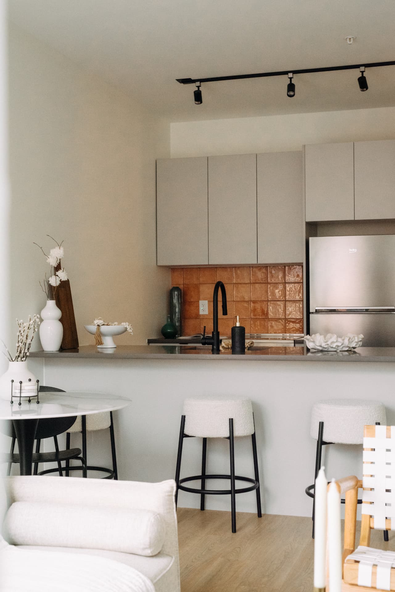 Residence kitchen with terracotta tile backsplash and boucle counter stools