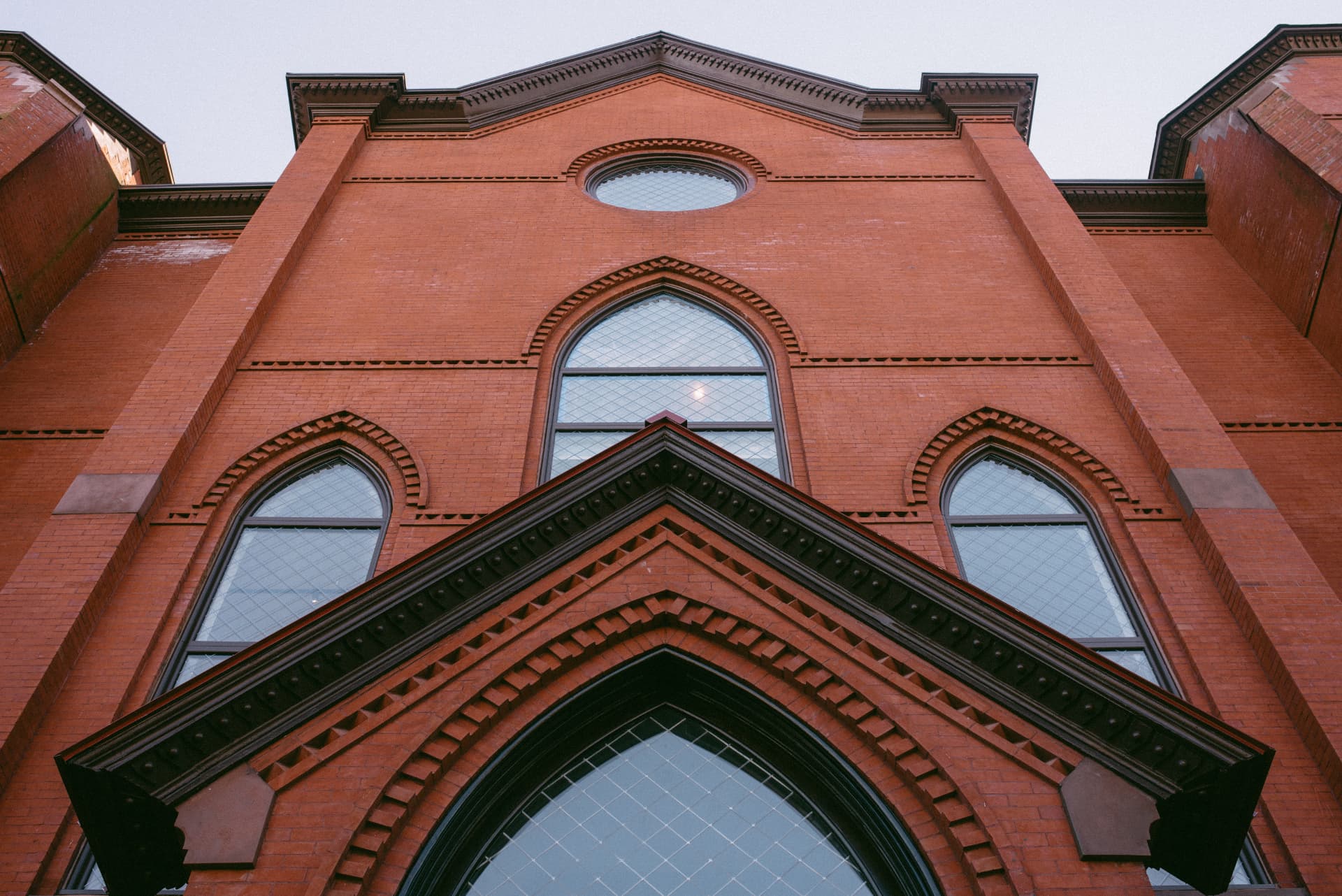 Original red brick facade with arched windows and ornate masonry