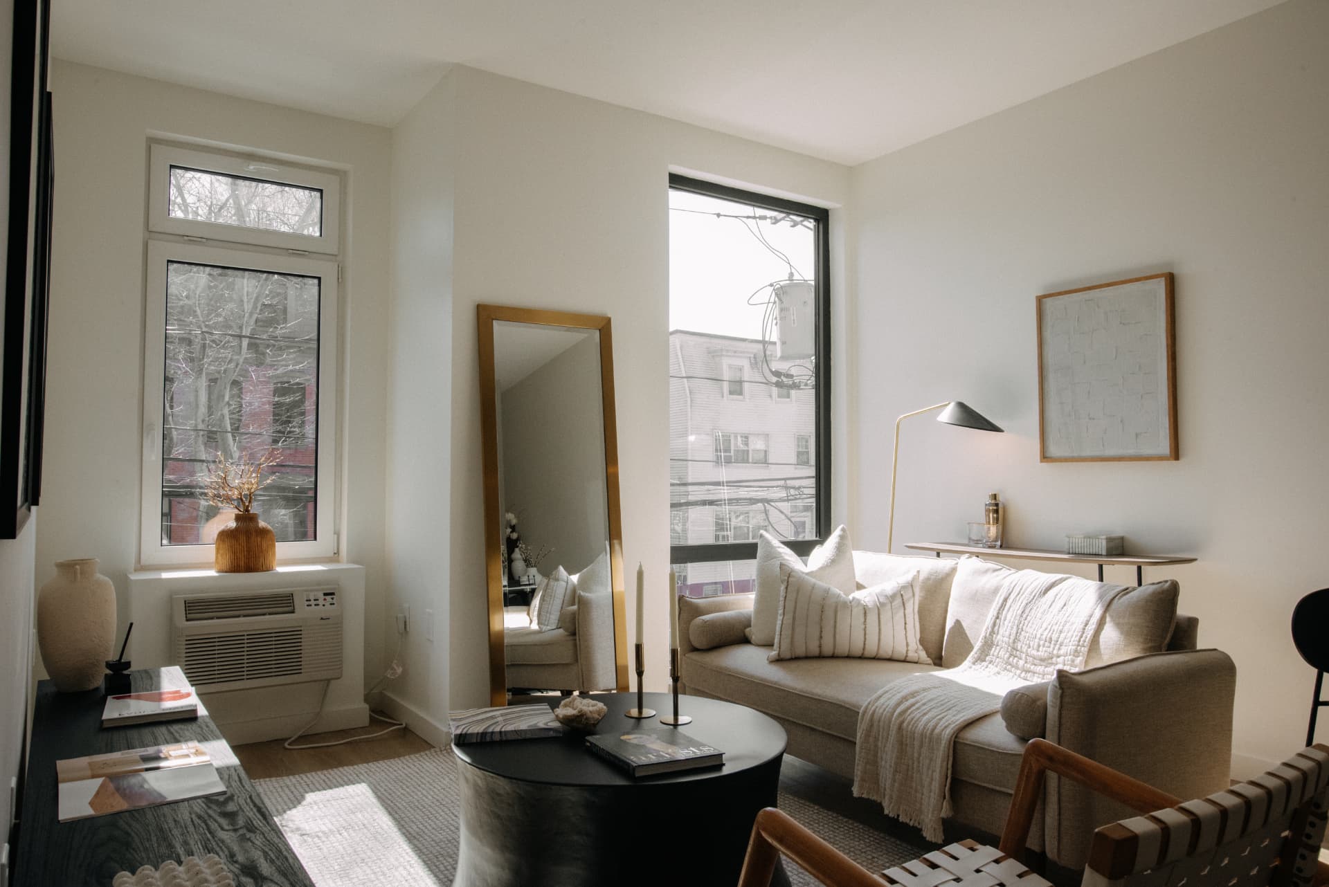 Residence living room with floor mirror, linen sofa and morning light